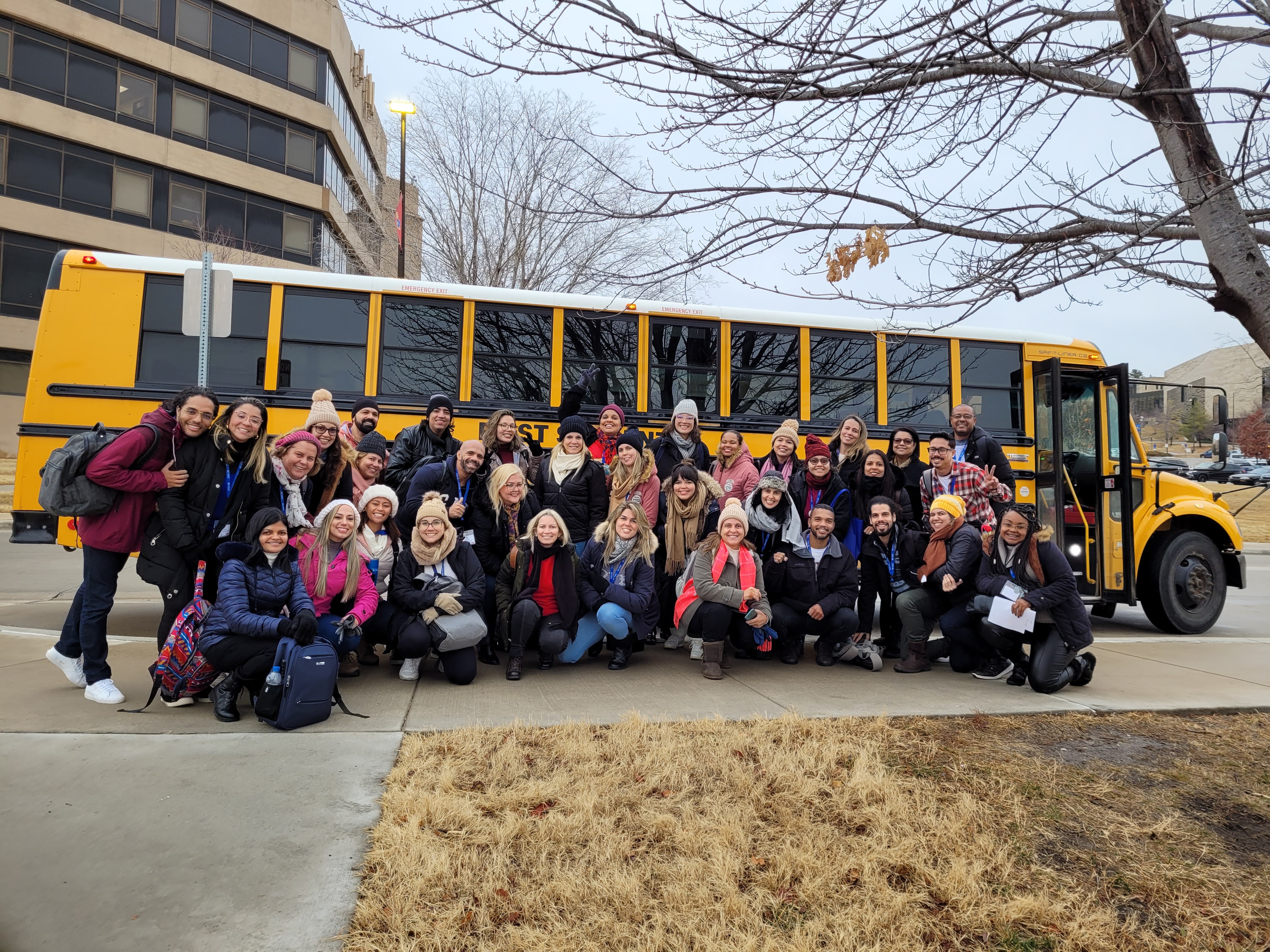 Brazilian English teachers in front of a yellow school bus